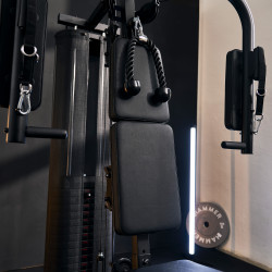 Close-up of the tricep rope above the backrest, and padded pec-deck arms of the press/pull arm module with strap handles for chest flyes