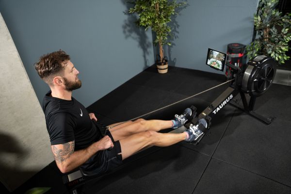 Eine Person in Sportbekleidung trainiert auf einem Taurus Elite Rower.