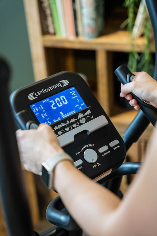 Person in Sportkleidung trainiert auf dem Taurus FX10.5. Das Ger&auml;t steht in einer dunklen Halle und ist mit einem Spotlight ausgeleuchtet.