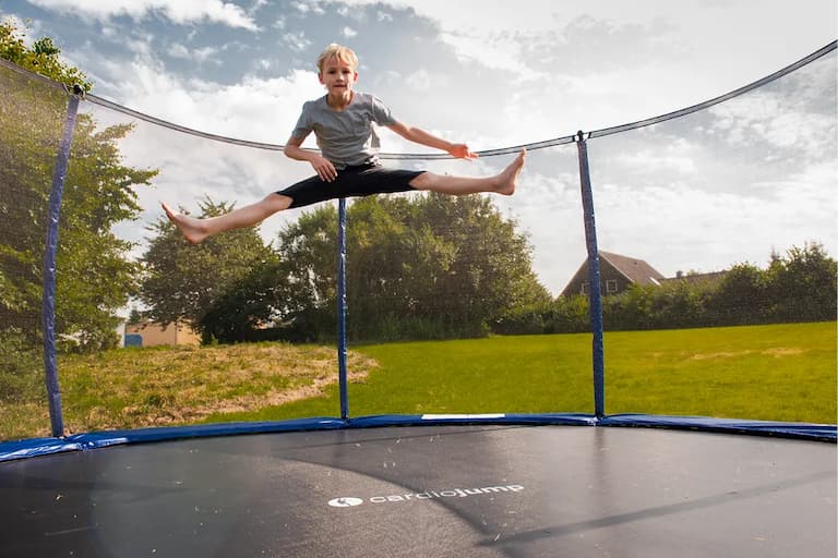 Kind springt auf Trampolin.