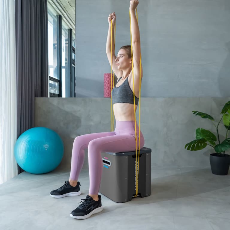 Person in Trainingskleidung trainiert auf einem Trainings-Cube von Horizon mit Widerstandsbändern.