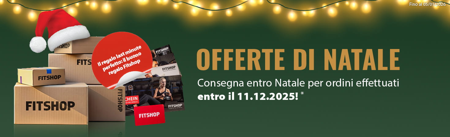 Un banner pubblicitario natalizio con sfondo verde e una ghirlanda luminosa nella parte superiore dell'immagine. Sul lato sinistro sono raffigurati diversi pacchetti con la scritta “Fitshop”. Accanto ad essi sono raffigurati diversi buoni regalo Fitshop. In un riquadro di testo evidenziato in rosso è riportata la scritta “Il regalo last minute perfetto: il buono regalo Fitshop”. Sul lato destro è scritto in maiuscolo “Offerte di Natale” con l'aggiunta “Consegna entro le feste per ordini effettuati entro l'11.12.2025!“