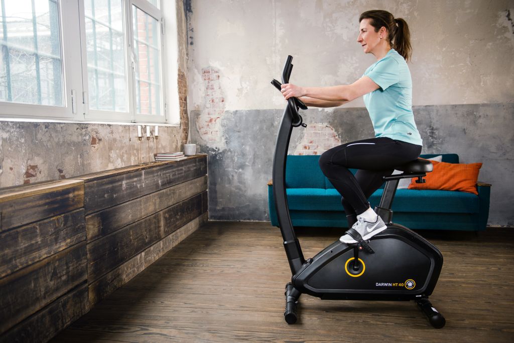 Eine Frau in Sportbekleidung trainiert auf einem Ergometer