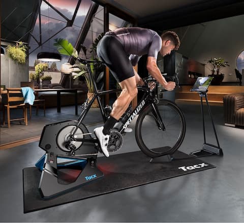 Un sportif s'entraîne sur un vélo fixé sur un home trainer à transmission directe