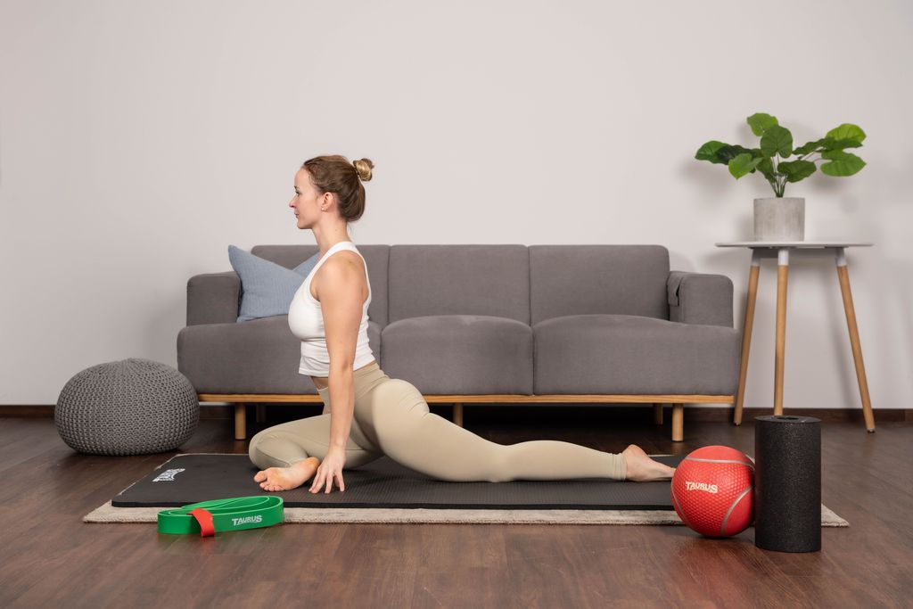 Une femme s'étire sur un tapis de yoga.