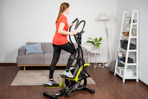 Frau trainiert auf Fitness Stepper im Wohnzimmer