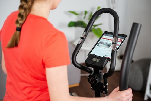 Frau trainiert auf Fitness Stepper mit Trainingscomputer