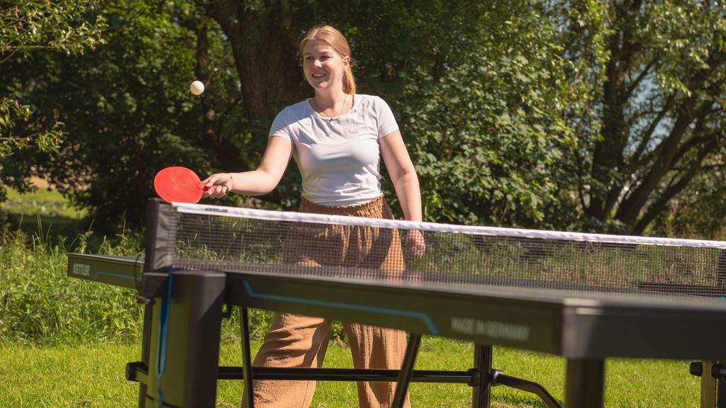 Frau spielt Titschtennis im Garten